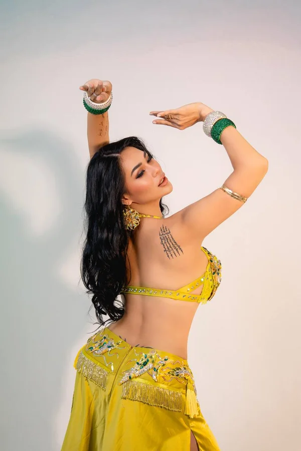 Professional belly dancer Elma in yellow traditional costume performing in Bali